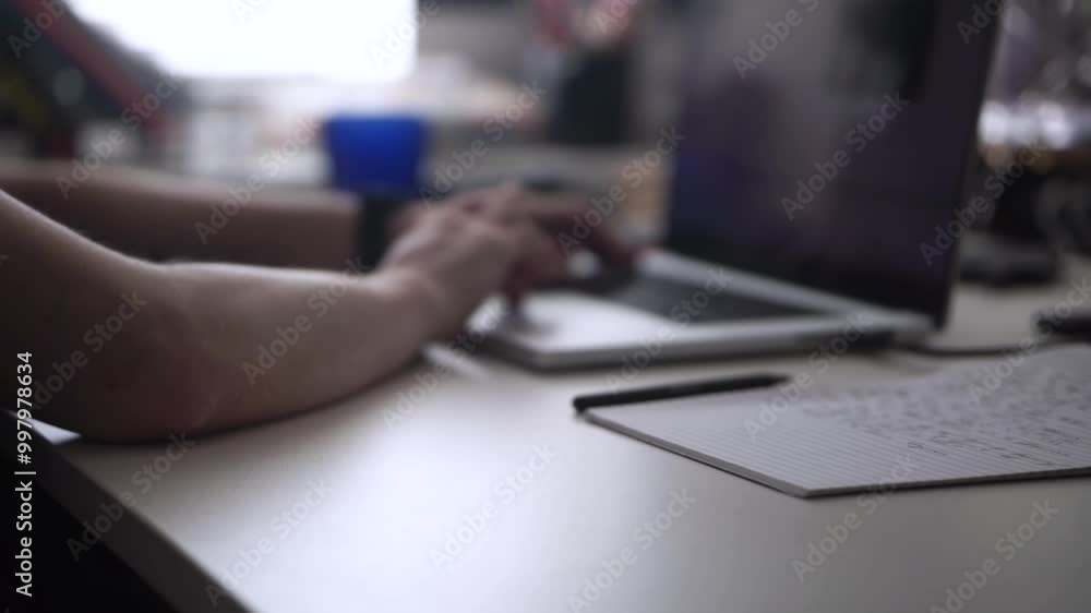 Man Working on Laptop and Taking Notes in Notebook Man Working on Laptop and Taking Notes in Notebook