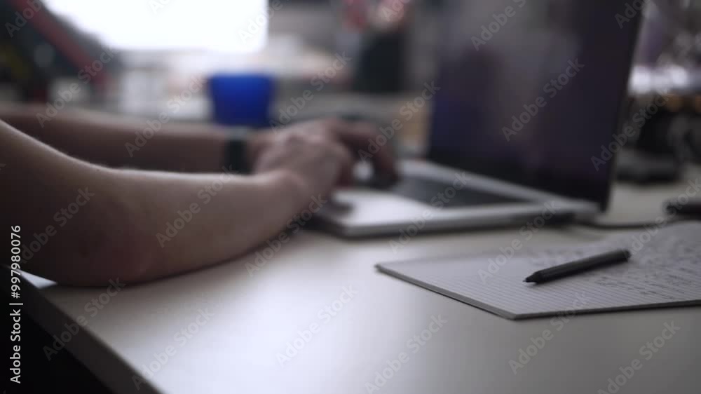 Man Working on Laptop and Taking Notes in Notebook Man Working on Laptop and Taking Notes in Notebook