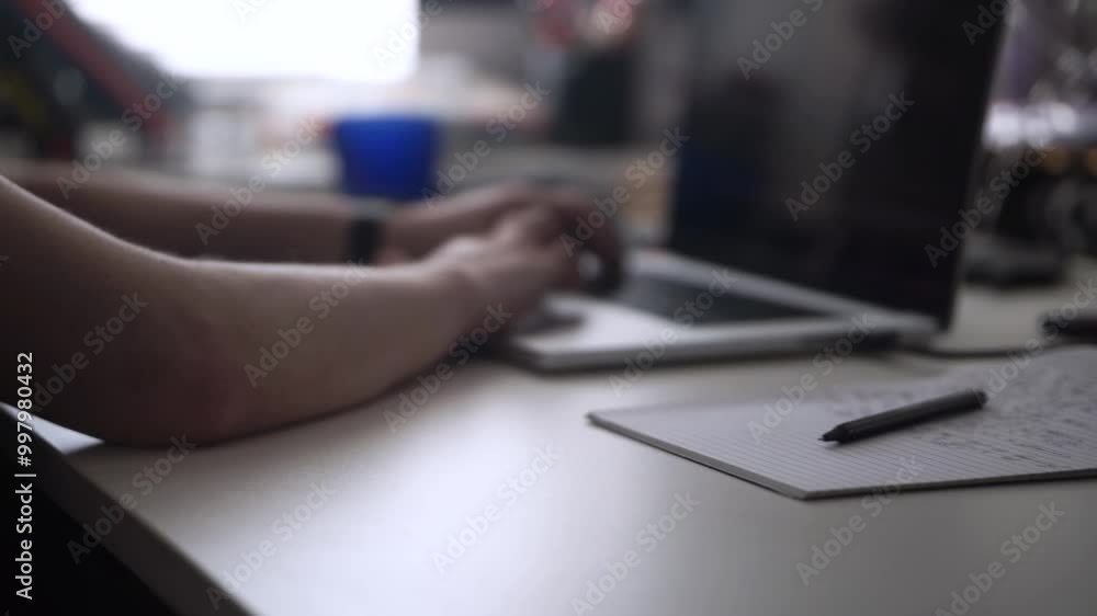 Man Working on Laptop and Taking Notes in Notebook Man Working on Laptop and Taking Notes in Notebook