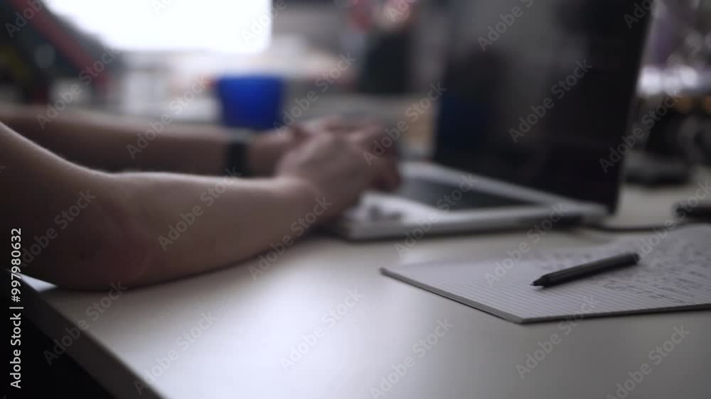 Man Working on Laptop and Taking Notes in Notebook Man Working on Laptop and Taking Notes in Notebook