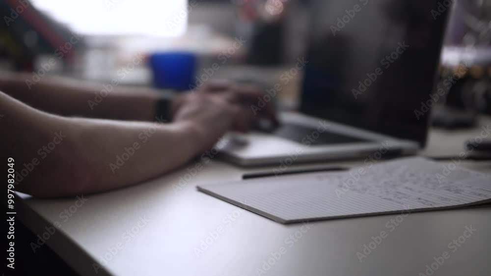 Man Working on Laptop and Taking Notes in Notebook Man Working on Laptop and Taking Notes in Notebook
