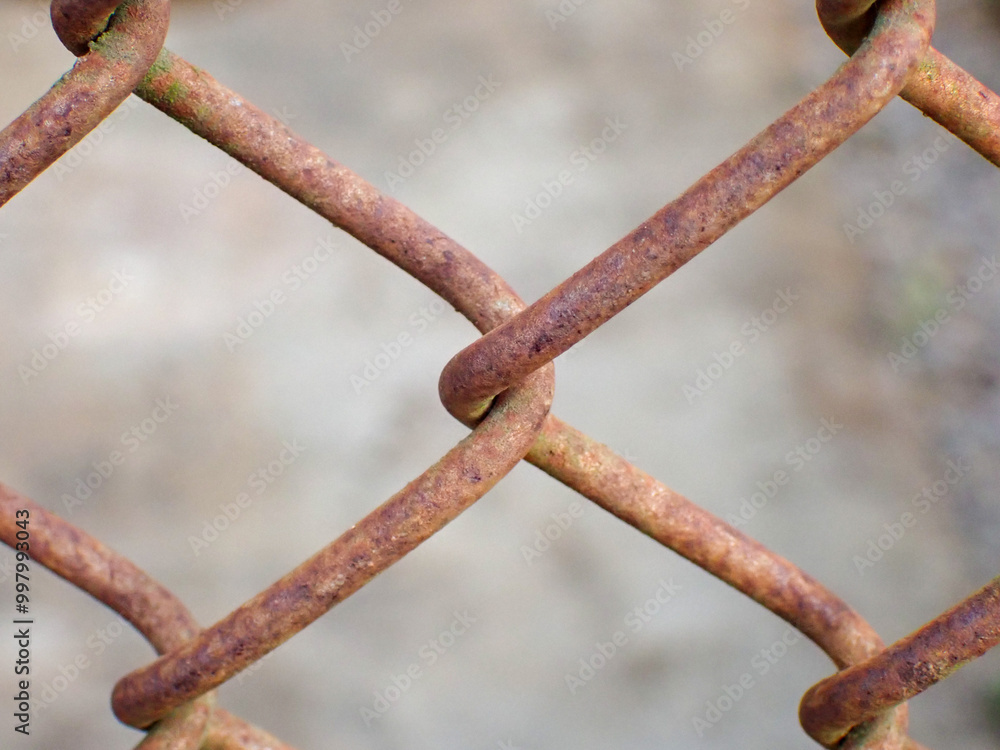 Chain link fence close up. Rusty steel mesh fence background. Texture of rusty metal wire. A perspective metal net wall with blur background. Chain link fence close up. Rusty steel mesh fence background. Texture of rusty metal wire. A perspective metal net wall with blur background.