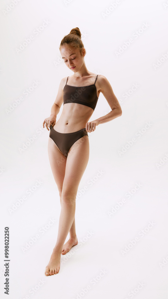 Full-length portrait of beautiful young woman in comfortable cotton underwear posing, showing her healthy slim body isolated on white background. Natural female beauty, body and skin care, health Full-length portrait of beautiful young woman in comfortable cotton underwear posing, showing her healthy slim body isolated on white background. Natural female beauty, body and skin care, health