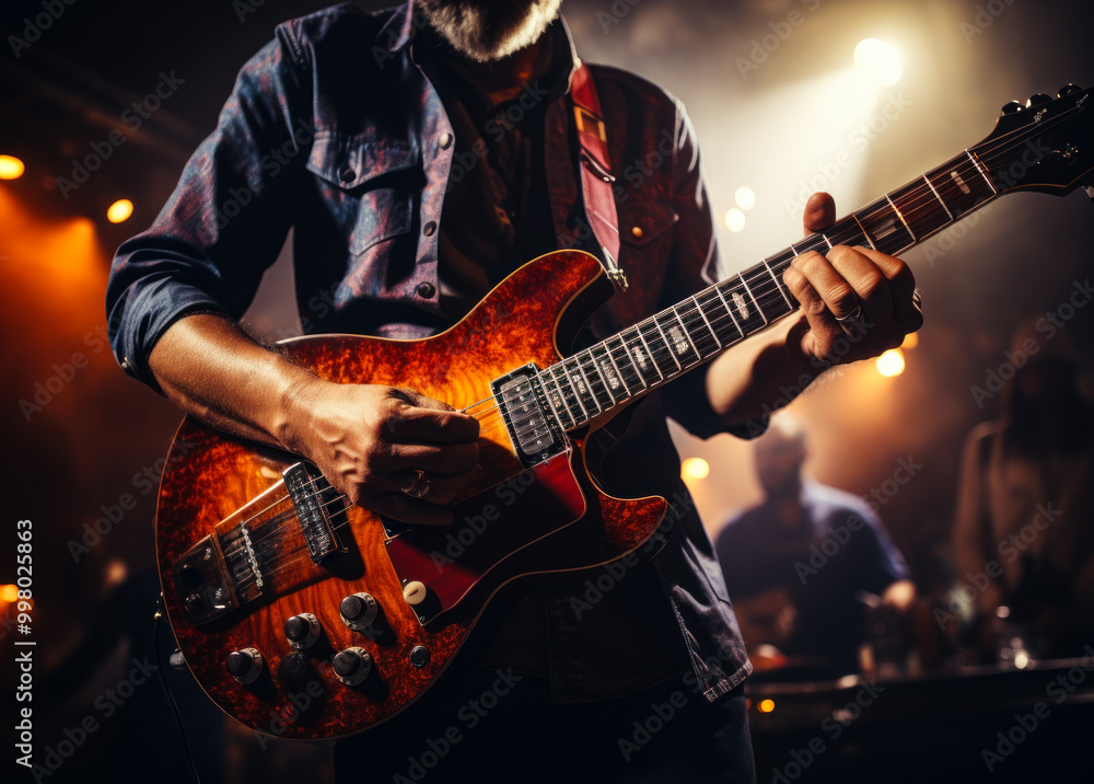 A man playing a guitar in a dimly lit room. Scene is relaxed and intimate A man playing a guitar in a dimly lit room. Scene is relaxed and intimate