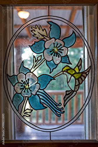 Canvastavla A stained glass hanging window panel of a hummingbird and flowers with small cra