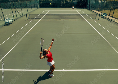 Slika na platnu Female tennis player serving during match on hardcourt
