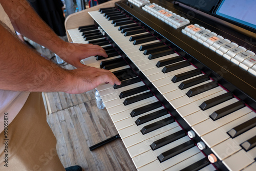 Organista num palco a tocar no seu órgão durante uma cerimónia religiosa ao ar livre photo