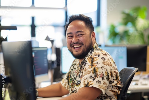 Cheerful Pacific Islander programmer man working with computers in office. , background blur