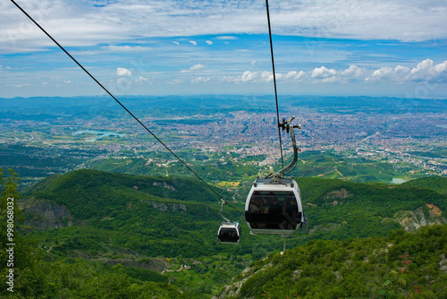 Cable cars ascend Mount Dajti, offering breathtaking panoramic views of the sprawling urban landscape below and the surrounding green countryside. Tirana, Albania