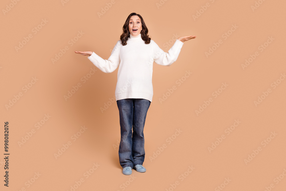Photo of adorable gorgeous senior woman wear stylish clothes recommend empty space isolated on beige color background Photo of adorable gorgeous senior woman wear stylish clothes recommend empty space isolated on beige color background