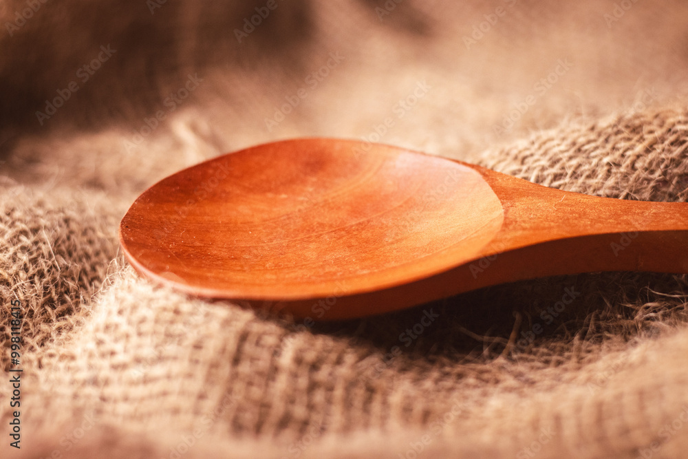 Closeup of a kitchen wooden spoon on a brown rug Closeup of a kitchen wooden spoon on a brown rug