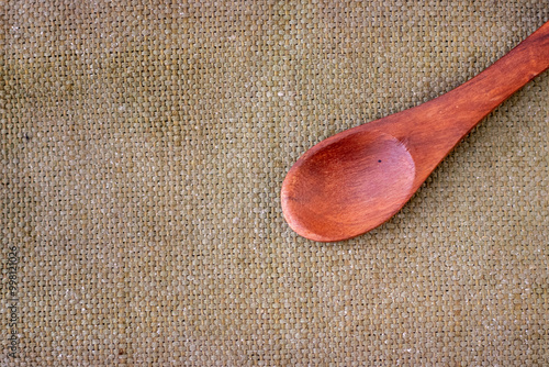 A empty wooden spoon on a brown background photo