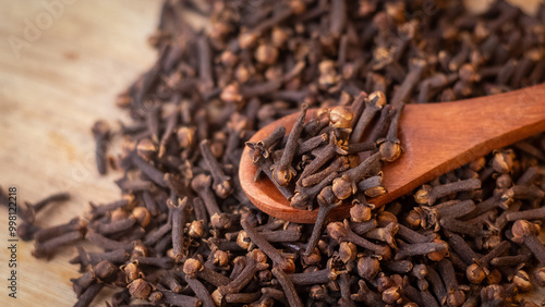Wallpaper Mural A close-up image of a pile of dried cloves on a wooden spoon. The cloves are a dark brown color and have a distinct, knobby shape. They are clustered together, showing their intricate textures Torontodigital.ca