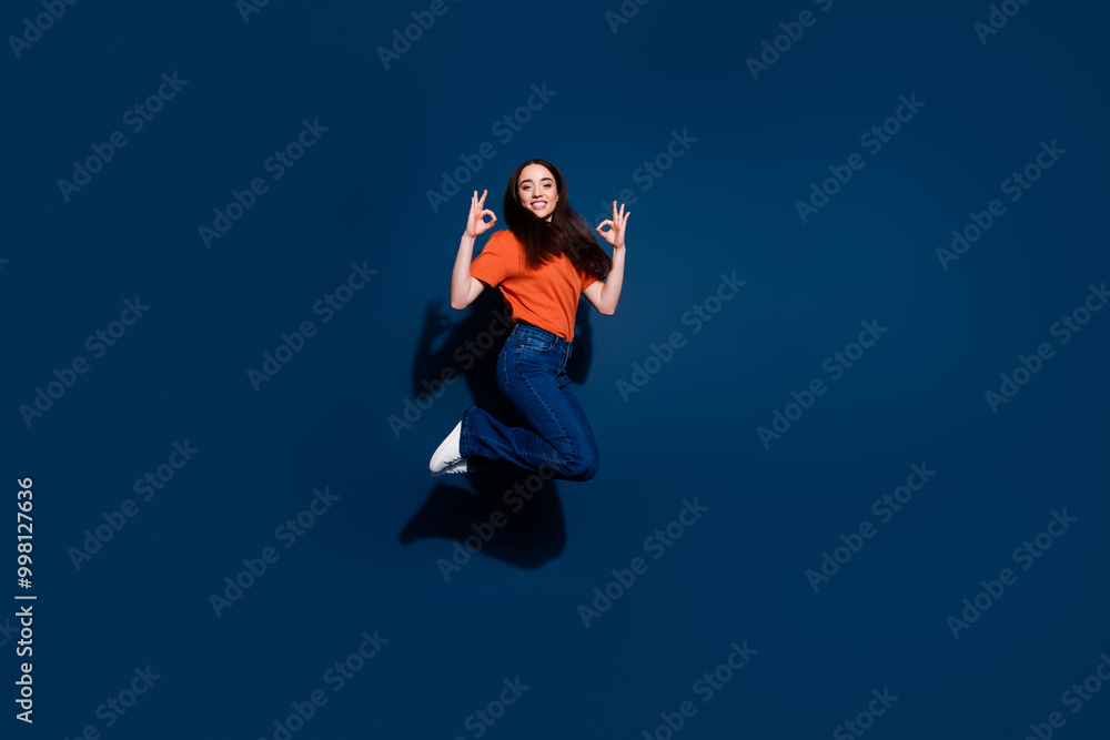 Photo of nice adorable cheerful woman wear orange trendy clothes outfit okey sign isolated on dark blue color background Photo of nice adorable cheerful woman wear orange trendy clothes outfit okey sign isolated on dark blue color background