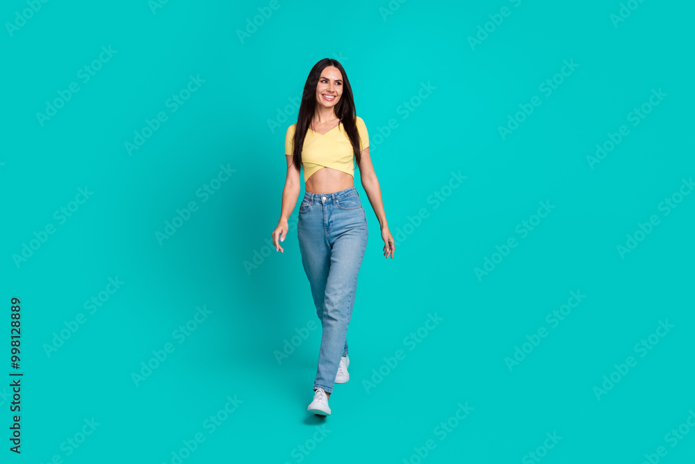 Full size photo of nice young woman walk look empty space wear top isolated on teal color background Full size photo of nice young woman walk look empty space wear top isolated on teal color background