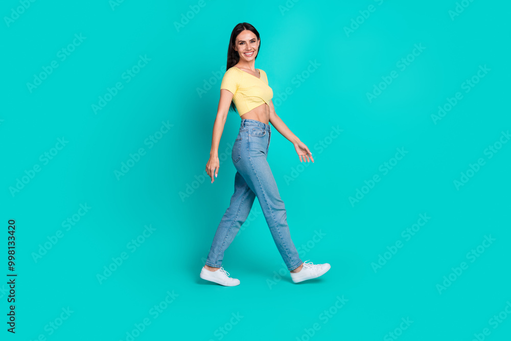 Full body profile portrait of pretty young woman walk empty space wear top isolated on turquoise color background Full body profile portrait of pretty young woman walk empty space wear top isolated on turquoise color background