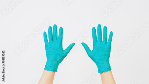 Hands is wear aqua mint green latex gloves on white background.