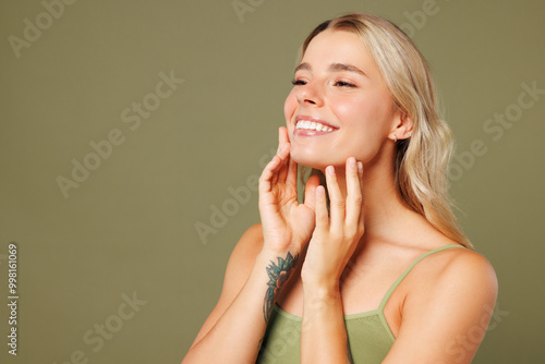 Close up side view young lady woman with slim skinny body perfect skin wear top bra lingerie stand touch face look aside on area isolated on plain pastel green background. Lifestyle diet fit concept. photo