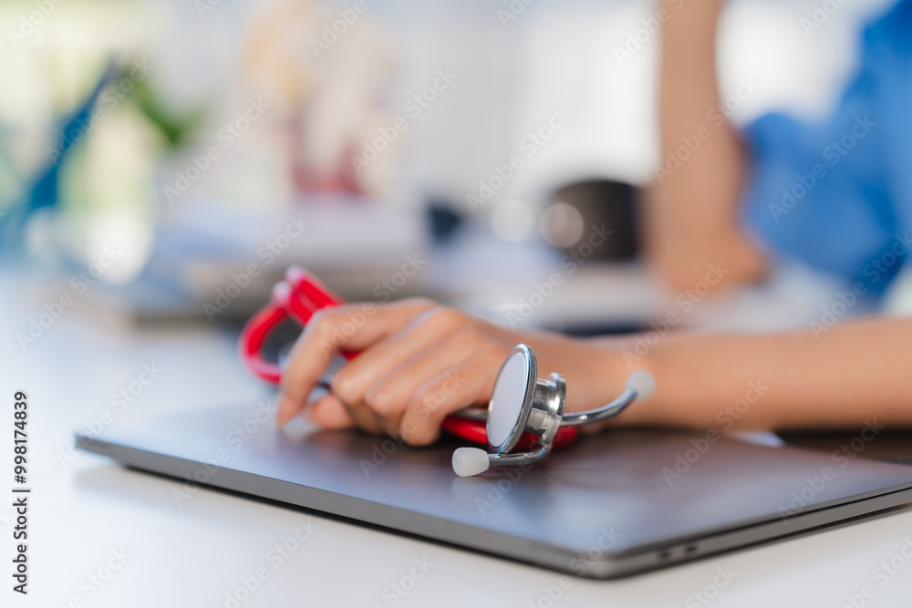 Fototapeta premium Doctor's Hands Holding Stethoscope on Laptop