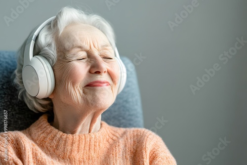 A joyful elderly lady in headphones eyes closed enjoy photo