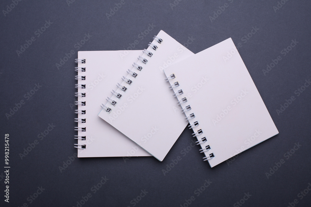 White blank spiral notebooks on dark gray background. White blank spiral notebooks on dark gray background.