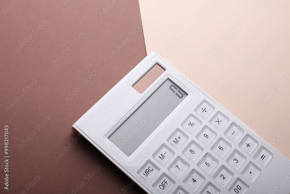 White plastic calculator on beige brown bckground close up White plastic calculator on beige brown bckground close up