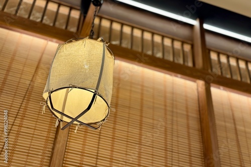 Elegant Japanese Lantern Hanging Inside a Traditional Room with Wooden and Bamboo Decor