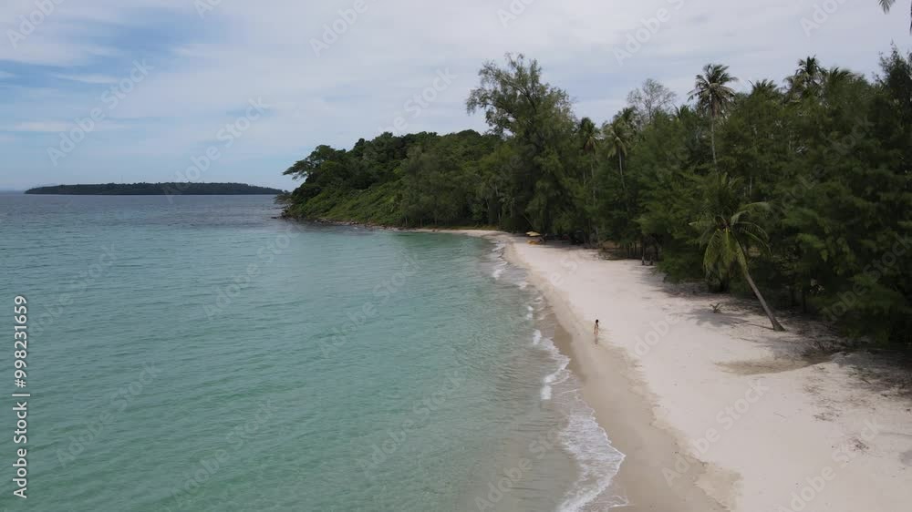 Top view of woman in swimsuit walking alone on the beach.Green sea water, white sand beach, green forest on the shore thailand Top view of woman in swimsuit walking alone on the beach.Green sea water, white sand beach, green forest on the shore thailand