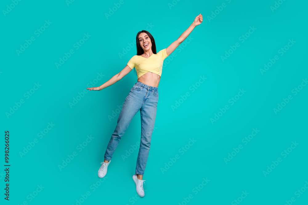 Obraz premium Full size photo of pretty young woman jump arm hold empty space wear top isolated on teal color background