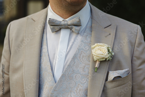 Grooms elegant, grey, suit with bow and white rose
 photo