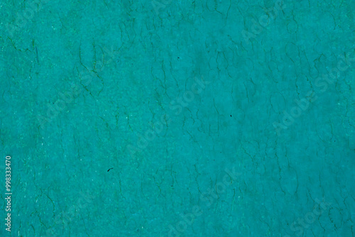A vibrant teal textured background with a grunge effect. Ideal for use in graphic design, presentations, or as a creative backdrop for various projects, offering a bold and abstract visual element.
