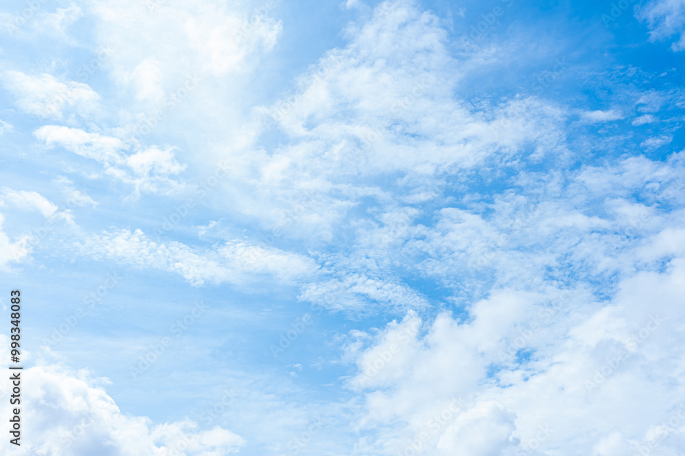 Fluffy white clouds drift across a vibrant blue sky, creating a breathtaking natural spectacle Fluffy white clouds drift across a vibrant blue sky, creating a breathtaking natural spectacle
