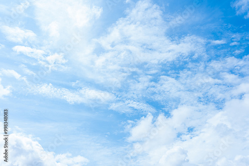 Fluffy white clouds drift across a vibrant blue sky, creating a breathtaking natural spectacle