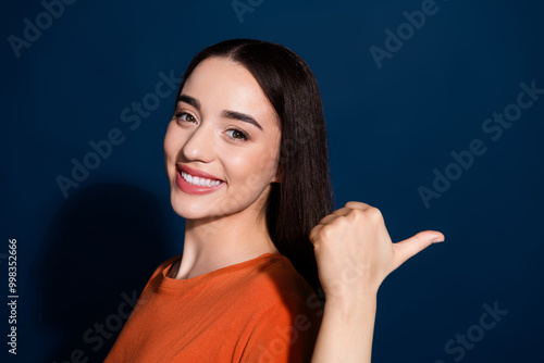 Photo of cute gorgeous woman wear stylish orange clothes presents empty space news isolated on dark blue color background