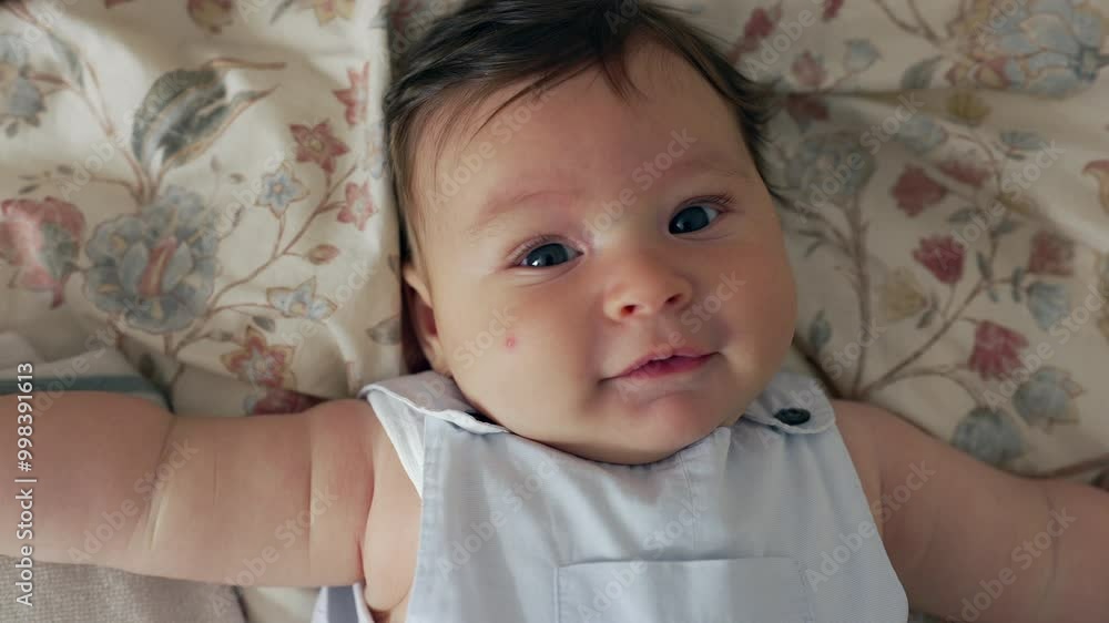 Close-up of a baby lying on the bed, smiling softly towards the camera. Indoor scene capturing the baby’s joyful and content expression in a cozy home setting Close-up of a baby lying on the bed, smiling softly towards the camera. Indoor scene capturing the baby’s joyful and content expression in a cozy home setting