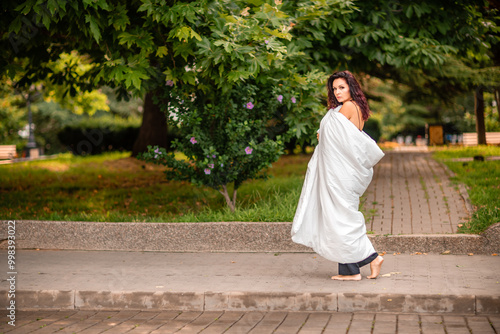 Woman city blanket. Morning in the big city. A blonde woman in a white blanket is enjoying in the city center. Photographed for social media