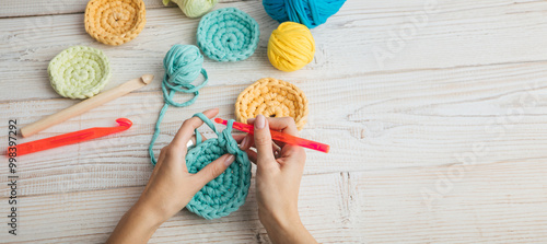 knitting crochet  woman hands top view. colorful balls of yarn blue, yellow and orange. Relaxing hand craft hobby time. Long horizontal banner