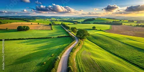 countryside path with lush green fields and blue sky aerial photo