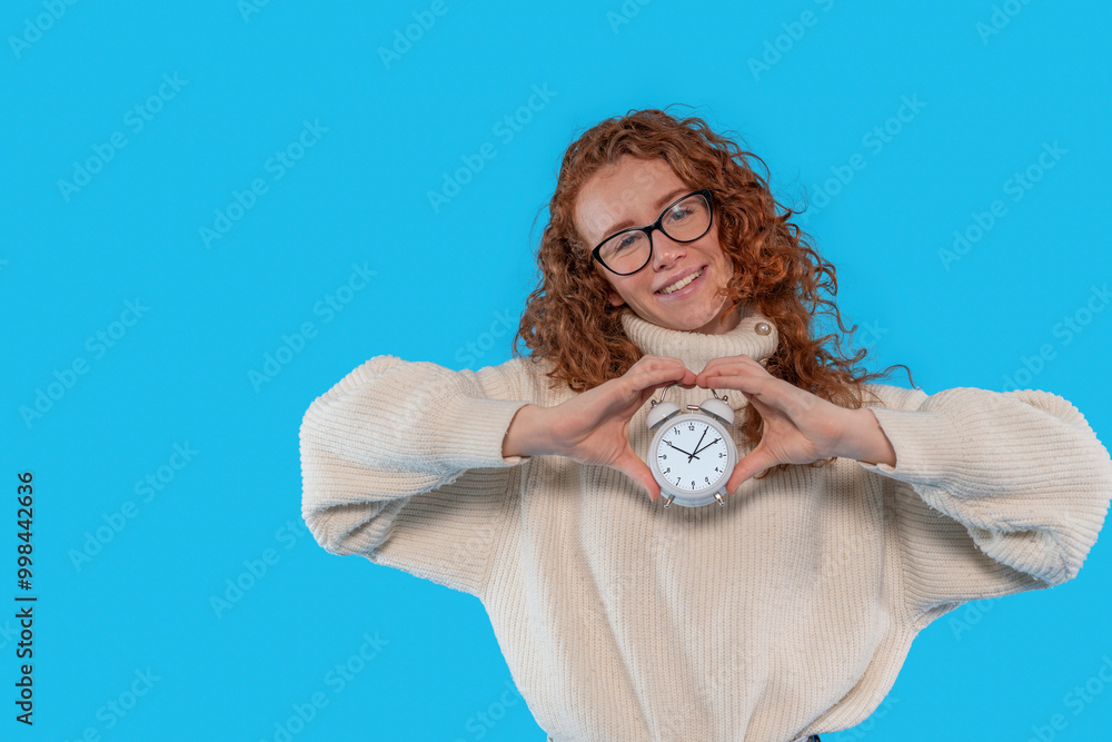 Joyful Woman With Curly Hair Holds Clock Against Bright Background Joyful Woman With Curly Hair Holds Clock Against Bright Background