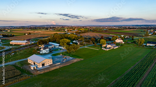 Photography An expansive aerial view captures the serene beauty of rural Pennsylvania at sunset, showcasing farmland, trees, and residential areas