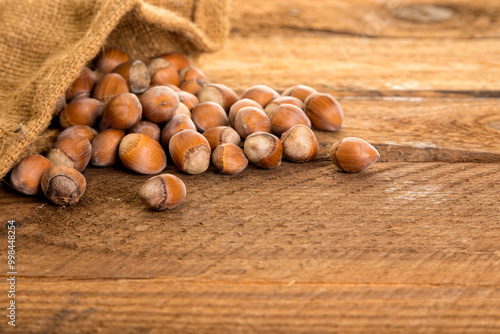 Hazelnuts in burlap bag on rustic table