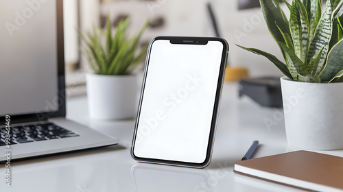 Wallpaper Mural Modern office setup with a smartphone, a laptop, and green plants on a white desk, showcasing clean and minimalistic workspace design. Torontodigital.ca