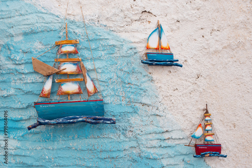 Wall ornaments in the shape of boats on a wall  in the streets of Pigadia, Karpathos, Greece. photo