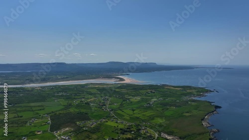 Tullan Strand, County Donegal, Ireland, June 2023. Drone gradually ascends and pulls backwards above the scenic Rossnowlagh coastline with the Sligo mountains in the distance under a clear blue sky. photo