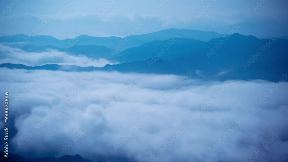 A breathtaking panoramic view of a sea of clouds below a crescent moon and a starry night sky. The silhouette of distant mountains adds depth and drama to this serene landscape. Xindian, Taiwan. A breathtaking panoramic view of a sea of clouds below a crescent moon and a starry night sky. The silhouette of distant mountains adds depth and drama to this serene landscape. Xindian, Taiwan.