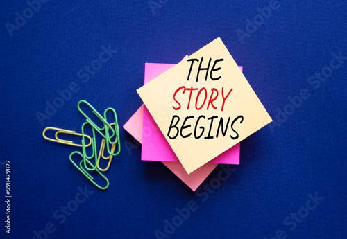 The Story Begins symbol. Steaky notes with words The Story Begins. Beautiful deep blue background. Business and The Story Begins concept. Copy space. photo