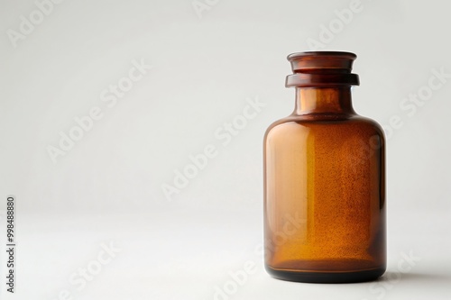 Amber apothecary bottle with a glass stopper is standing on a white background