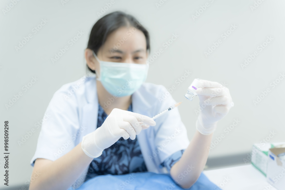 Doctor's hand holding syringe and bottle for HPV (Human papilloma virus) vaccination.Vaccine for protection Coronavirus (Covid-19) infection.Vaccination for flu treatment. Doctor's hand holding syringe and bottle for HPV (Human papilloma virus) vaccination.Vaccine for protection Coronavirus (Covid-19) infection.Vaccination for flu treatment.