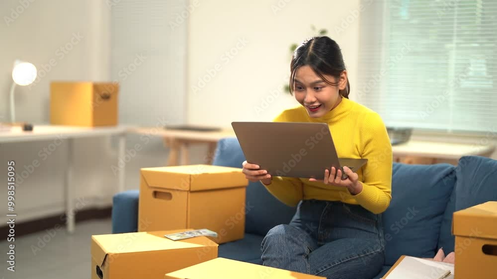 Young asian woman celebrating good news about her online store while working from home. Excitement fills the air as she receives updates on sales and business progress Young asian woman celebrating good news about her online store while working from home. Excitement fills the air as she receives updates on sales and business progress