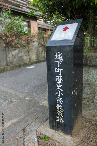 Stone historical sign post standing on street in Japanese castle town